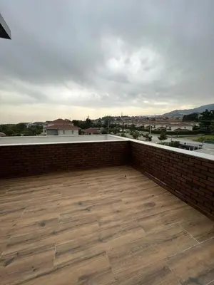 a balcony with a brick wall and a wooden floor at Serim Residence in Kocaeli
