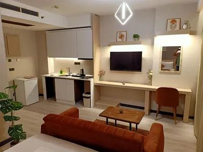 a living room with a couch and a table and a kitchen at Doğan Palace Hotel in Istanbul