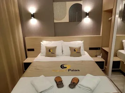 a hotel room with a bed with two slippers on it at Doğan Palace Hotel in Istanbul