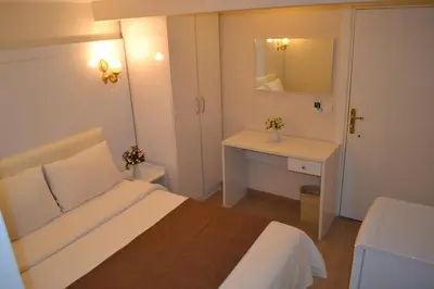 a bedroom with a bed and a sink and a mirror at New Fatih Hotel in Istanbul