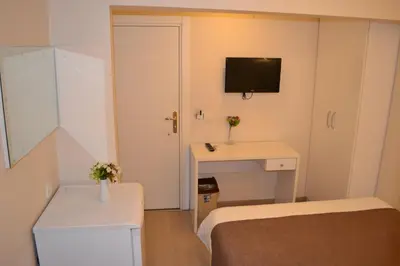 a small room with a bed and a desk and a tv at New Fatih Hotel in Istanbul