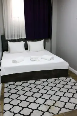 a bedroom with a large bed with a black and white rug at Avist Hotel Avcılar in Avcılar