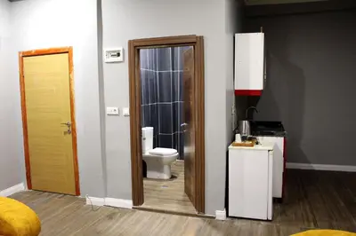 a bathroom with a toilet and a door to a room at Avist Hotel Avcılar in Avcılar