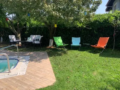 a group of chairs sitting in the grass next to a pool at Villa Elysium in Gebze