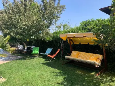 a backyard with a couch and chairs under an umbrella at Villa Elysium in Gebze