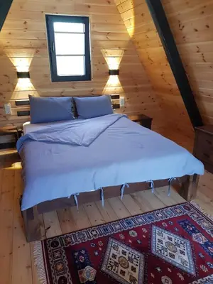 a bedroom with a large bed in a log cabin at Teona Kartepe Bungalov in Kartepe