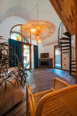 a large living room with a chandelier and a staircase at Feronia Suites in Masukiye