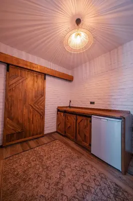 an empty room with wooden cabinets and a refrigerator at Feronia Suites in Masukiye