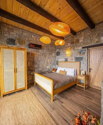 a bedroom with a bed and a stone wall at Mjoraste Sapanca Boutique Villas in Sapanca