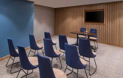 a room with chairs and a table and a tv at Hampton By Hilton Istanbul Sirkeci in Istanbul