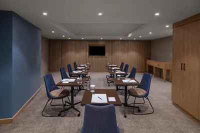 a conference room with tables and chairs and a screen at Hampton By Hilton Istanbul Sirkeci in Istanbul