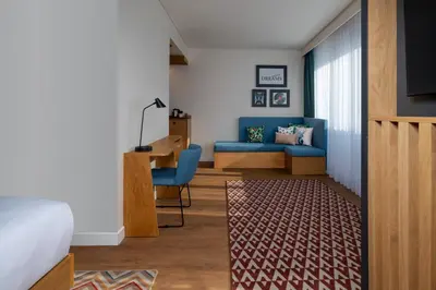 a bedroom with a blue couch and a desk at Hampton By Hilton Istanbul Sirkeci in Istanbul
