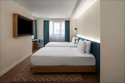 a hotel room with two beds and a flat screen tv at Hampton By Hilton Istanbul Sirkeci in Istanbul