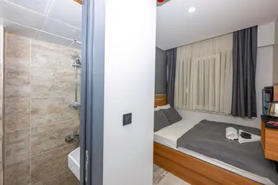 a small bedroom with a bed and a shower at mayza otel in Istanbul