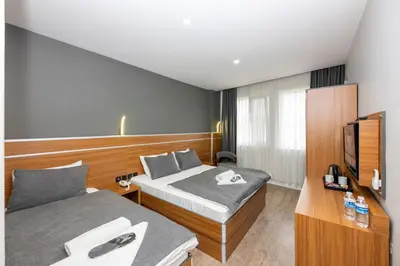 a hotel room with two beds and a television at mayza otel in Istanbul