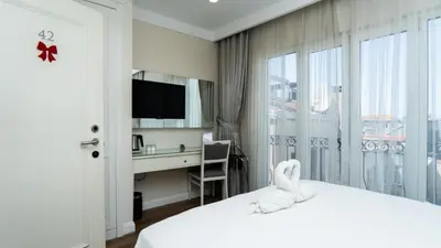 a hotel room with a bed with a desk and a window at Ten Rooms Istanbul Hotel in Istanbul