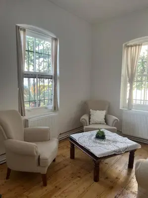 a living room with a coffee table and two chairs at Büyükada Al Köşk in Buyukada