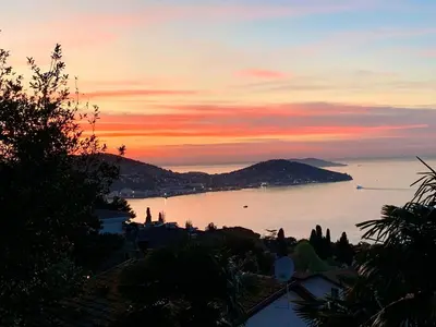 a sunset over a body of water with a city at Büyükada Al Köşk in Buyukada