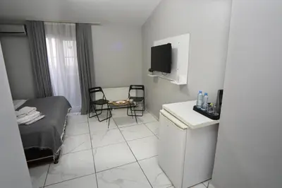 a small white room with a bed and a table at Arkem Maltepe in Istanbul