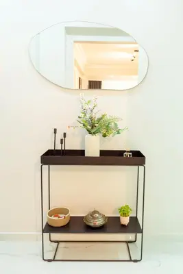 a mirror on top of a shelf with flowers at Charming Bagdat Avenue Hideaway, Near Marina in Istanbul