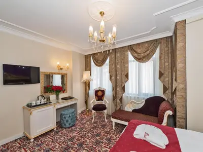 a hotel room with a bed and a chandelier at Galatower Hotel in Istanbul