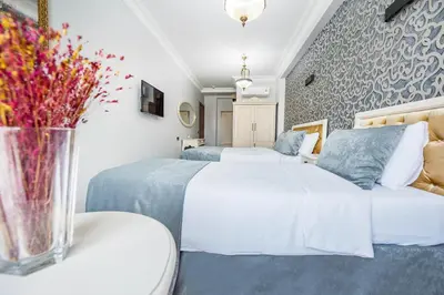 a hotel room with two beds and a vase of flowers at Pera Life in Istanbul