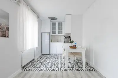 a white kitchen with a table and a refrigerator at Bright Private Modern 2BD1Bath Bebek Gem! #247 in Istanbul