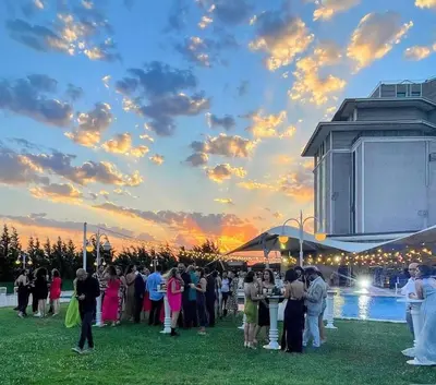 a group of people standing in a field at sunset at Burgaz İzer Hotel in Lüleburgaz