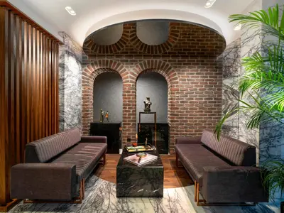 a living room with two couches and a brick wall at Nex Hotel & Spa Istanbul in Istanbul