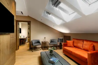 a living room with an orange couch and a tv at Nex Hotel & Spa Istanbul in Istanbul
