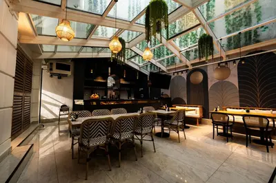 a restaurant with tables and chairs and a glass ceiling at Mona Bosphorus Hotel in Istanbul