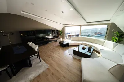 a living room with a white couch and a tv at Mona Bosphorus Hotel in Istanbul