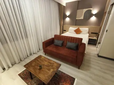 a hotel room with a couch and a bed at NEW FALCON PALAS OTEL in Istanbul