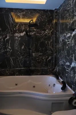 a bath tub in a bathroom with a black wall at Sapanca Villa View Suite in Sapanca