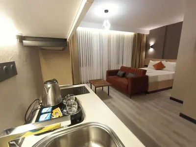 a hotel room with a bed and a kitchen with a sink at NEW FALCON Palas OTEL in Istanbul