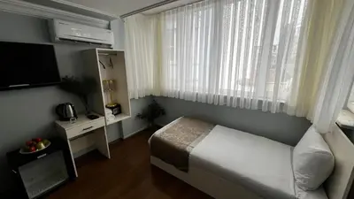 a small bedroom with a bed and a window at Bali Star City Hotel in Istanbul