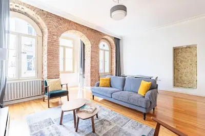 a living room with a blue couch and a brick wall at Warm Rustic Charming 2BD Galata wPatio Gem! #320 in Istanbul