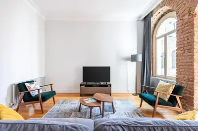 a living room with a couch and a tv at Warm Rustic Charming 2BD Galata wPatio Gem! #320 in Istanbul