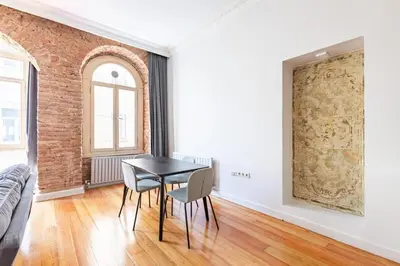 a dining room with a table and chairs and a brick wall at Warm Rustic Charming 2BD Galata wPatio Gem! #320 in Istanbul