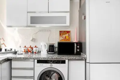 a kitchen with a washing machine and a microwave at Practical and Cozy Flat Near Taksim İstikal in Istanbul