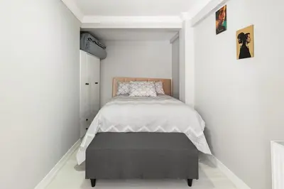 a small bedroom with a bed with a gray ottoman at Practical and Cozy Flat Near Taksim İstikal in Istanbul