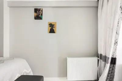 a bedroom with a bed and a window with pictures on the wall at Practical and Cozy Flat Near Taksim İstikal in Istanbul