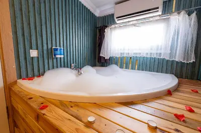 a bathroom with a white tub on a wooden floor at Süper Stay Halkalı in Istanbul