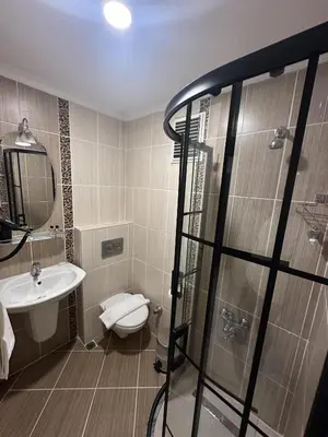 a bathroom with a shower and a toilet and a sink at Bella Otel Mudanya in Mudanya