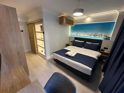 a bedroom with a king sized bed with a blue blanket at Bella Otel Mudanya in Mudanya