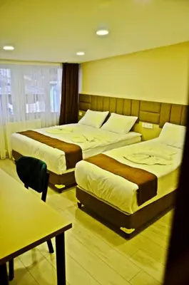 a hotel room with two beds and a table at Yesilirmak Aparts in Istanbul