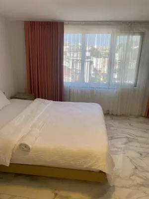 a bed in a room with a large window at YENİkapı in Istanbul