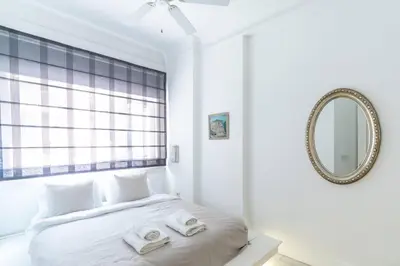 a white bedroom with a bed with two towels on it at Duplex Modern City Gem with Terrace in Istanbul
