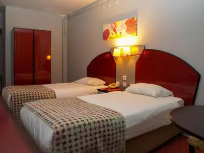 a hotel room with two beds and a table with a lamp at HOTEL EKEN in Bandırma