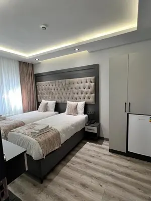 a hotel room with two beds and a television at Golden Stoneluxe İstanbul Hotel in Istanbul